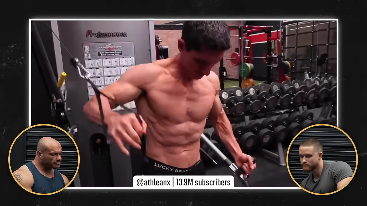 Athlean-X demonstrating a cable crossover with one arm high and the other low