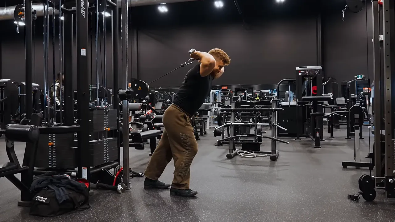 Side view of an overhead cable triceps extension with elbows bent and the bar behind the head