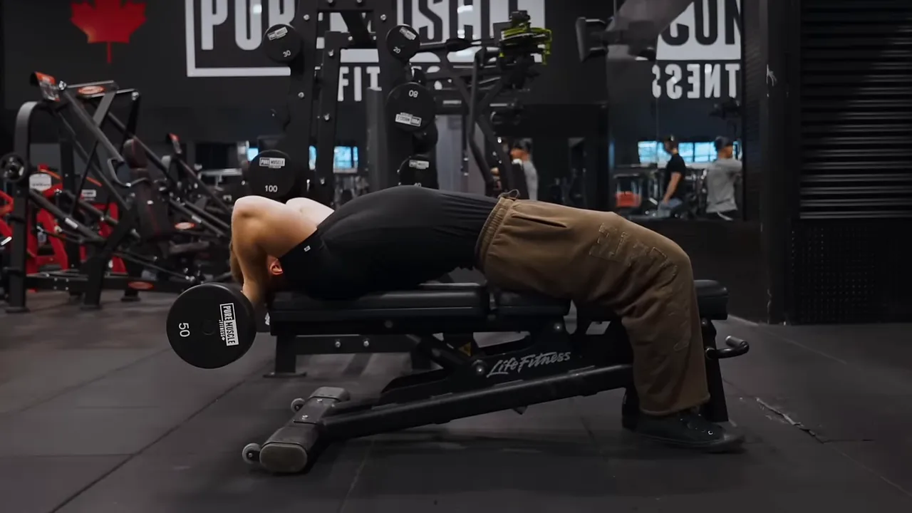Side view of a lying skull crusher with the bar lowered behind the head