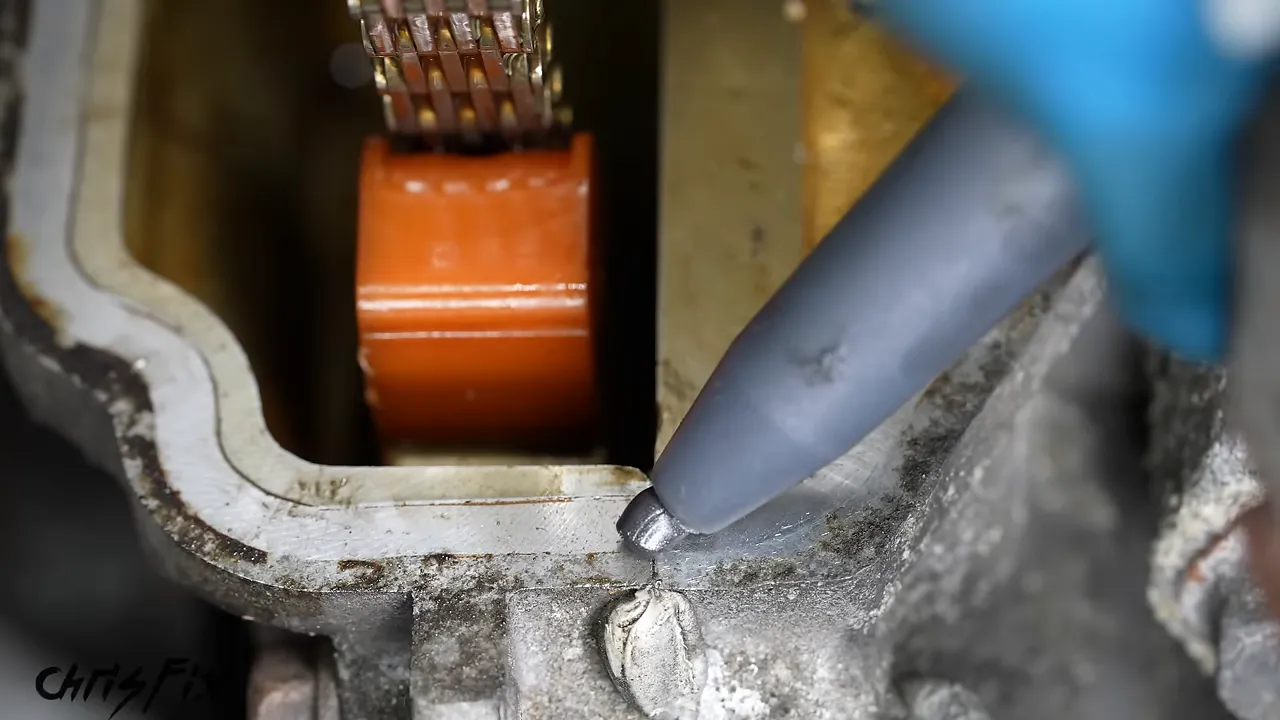 Small dab of RTV being applied at a casting joint along the valve cover sealing surface