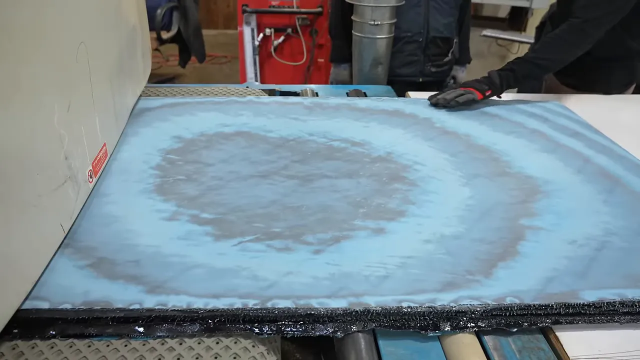Flattened denim slab showing broad concentric bands of light and dark blue