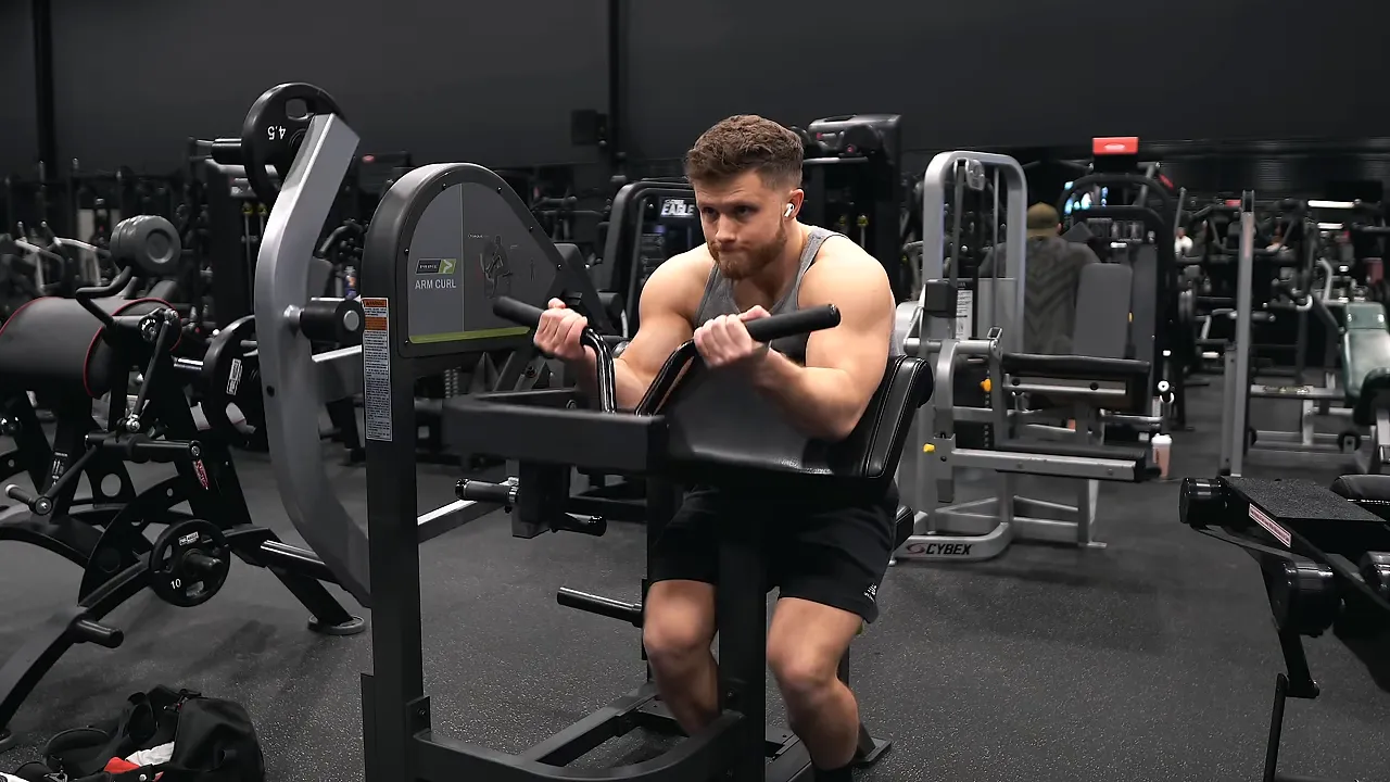 Jeff demonstrating a preacher curl with his arms extended near the bottom position