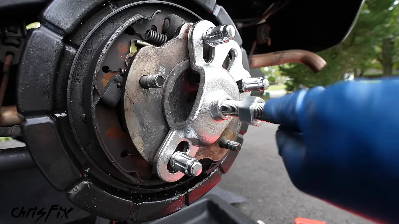 Slide hammer threaded into an axle flange adapter secured with three lug nuts