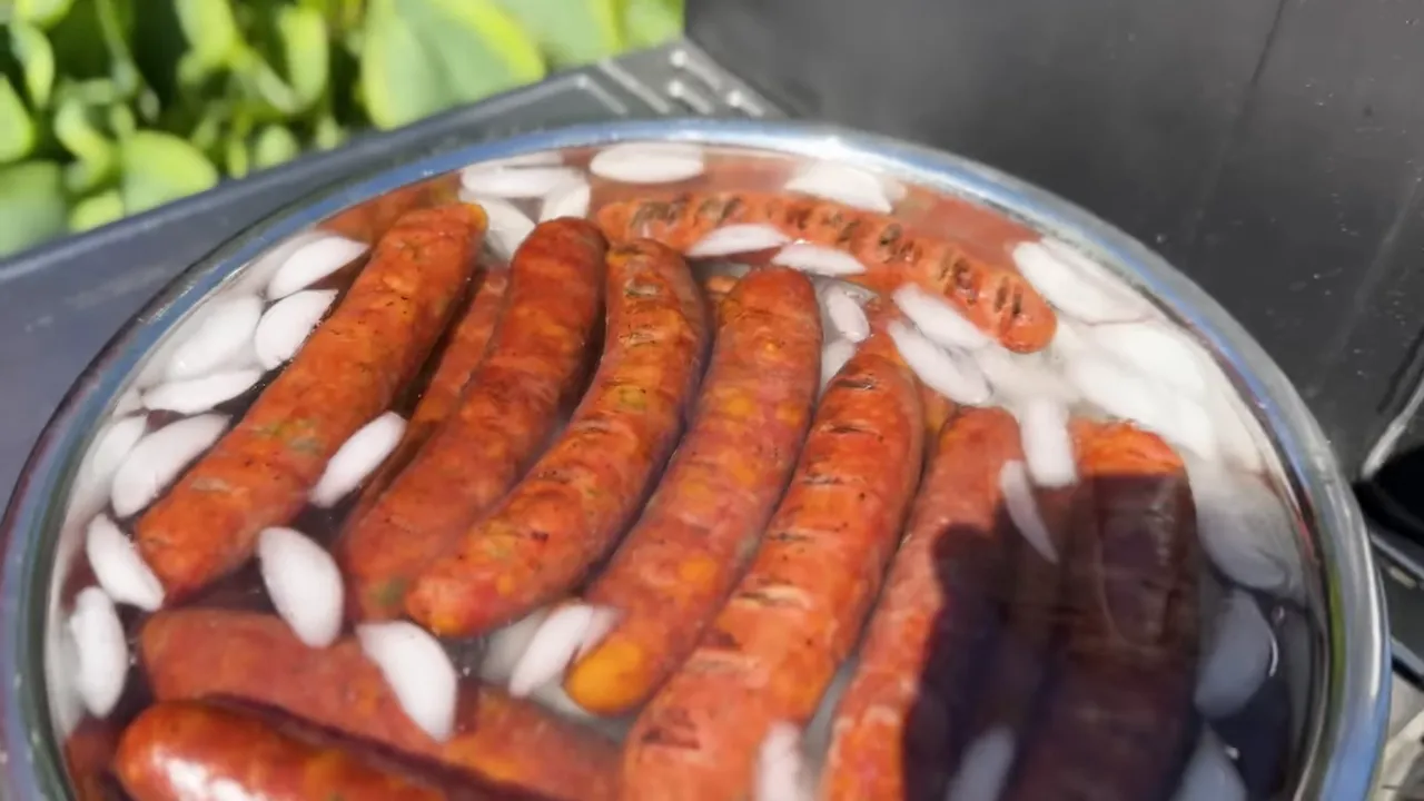 Smoked sausages submerged in a metal bowl of water and ice