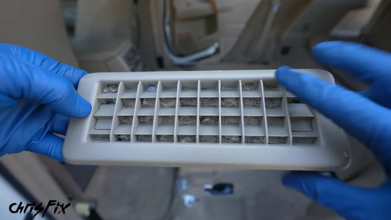 Back of a battery cooling intake grille covered with lint and debris