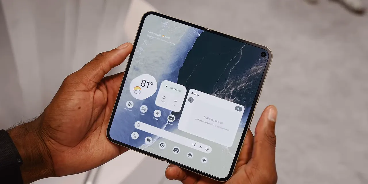 Unfolded Pixel Pro Fold held in two hands showing the inner home screen and surrounding bezels