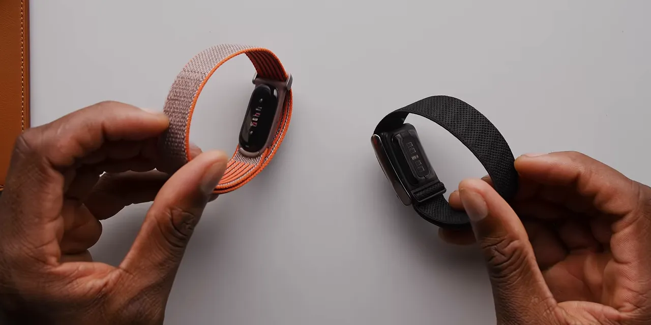 Fitbit Air and Whoop bands held side by side with their sensor undersides visible