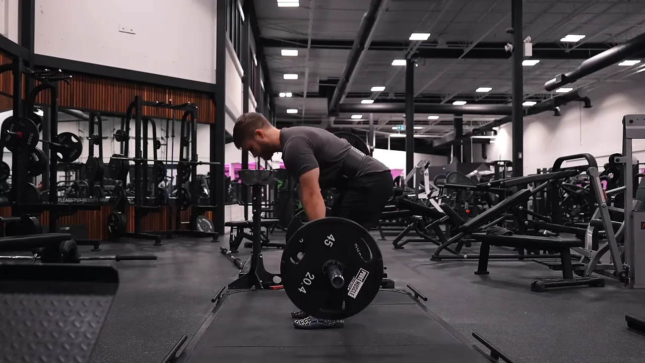 Side view of a stiff-legged deadlift with high hips and slightly bent knees