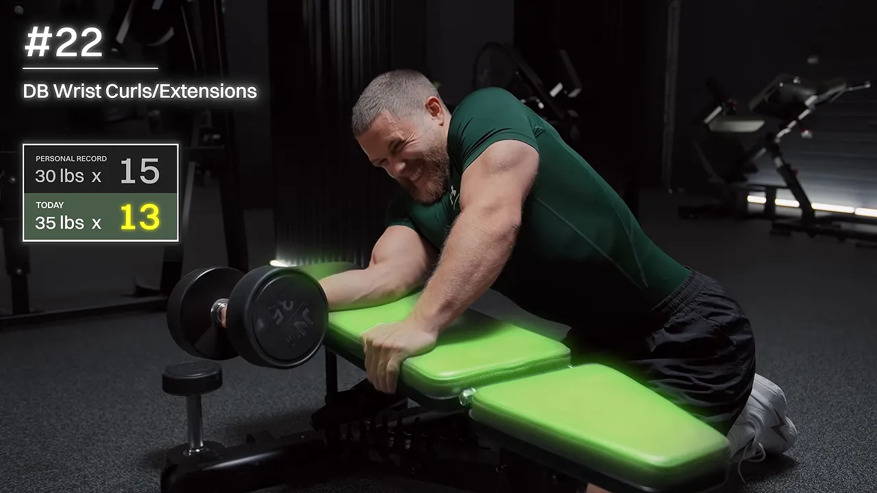 Lifter performing a dumbbell wrist curl with his forearm supported on a bench