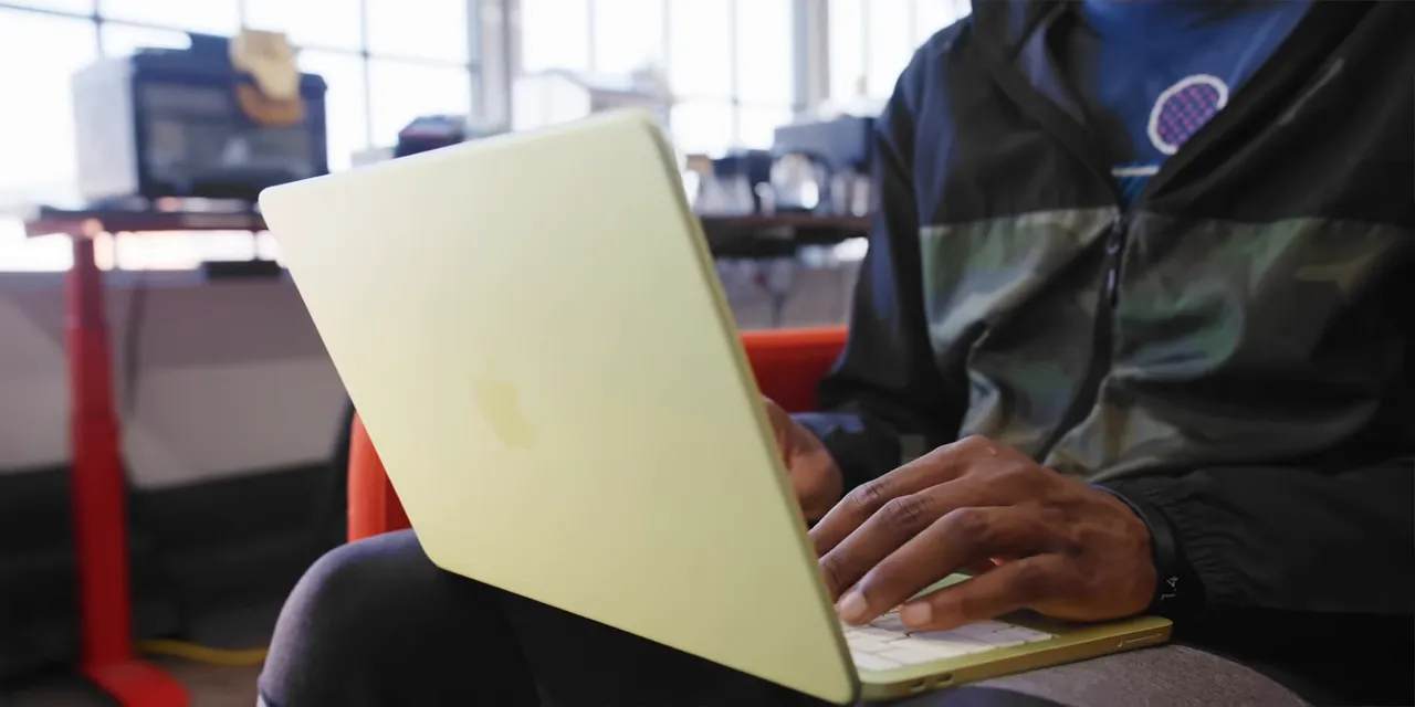 Close-up of the MacBook Neo keyboard corner with a Touch ID key and pale yellow keys