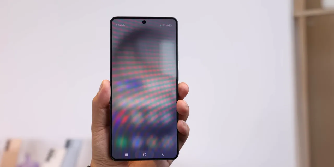 Samsung phone held upright with its home screen visible from the front