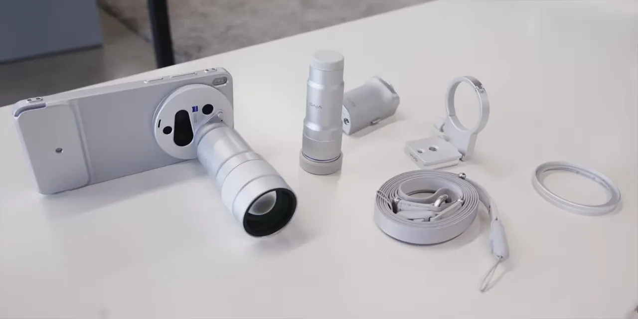 White Oppo phone camera kit with an attached telephoto lens, separate grip, rings, and cables on a table