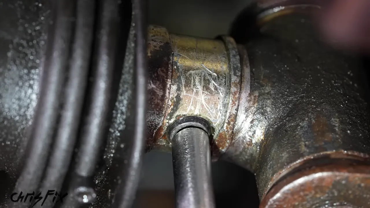 Close-up of a punch positioned against the spring pin in the transmission shift linkage