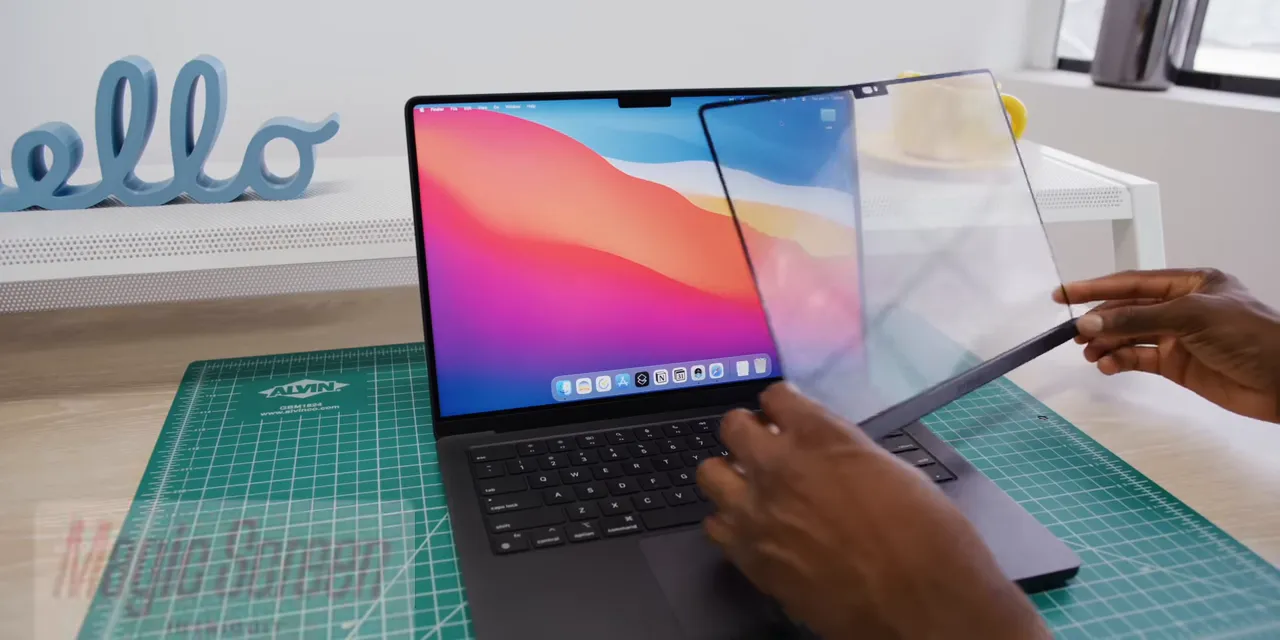 Hands positioning a transparent Magic Screen panel in front of a MacBook display