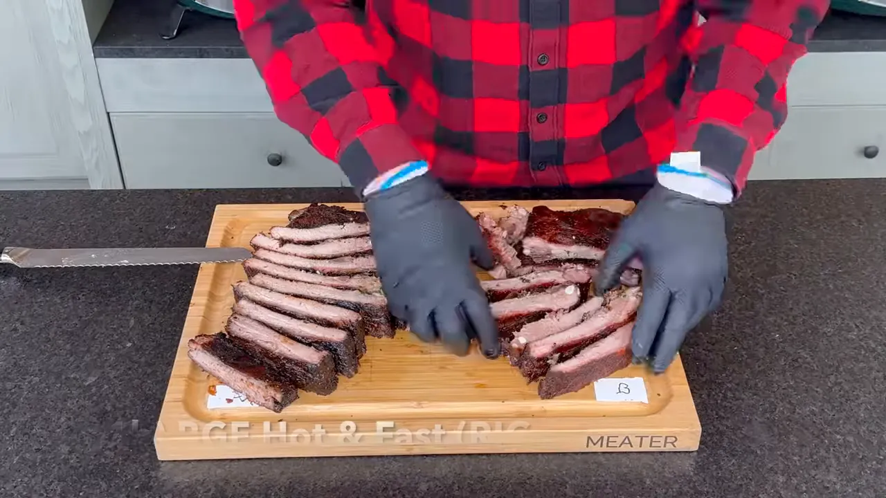 Two groups of sliced ribs on a cutting board with dark bark and pink edges