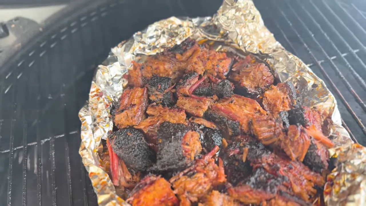 Sauced brisket burnt ends in an open foil boat on the grill