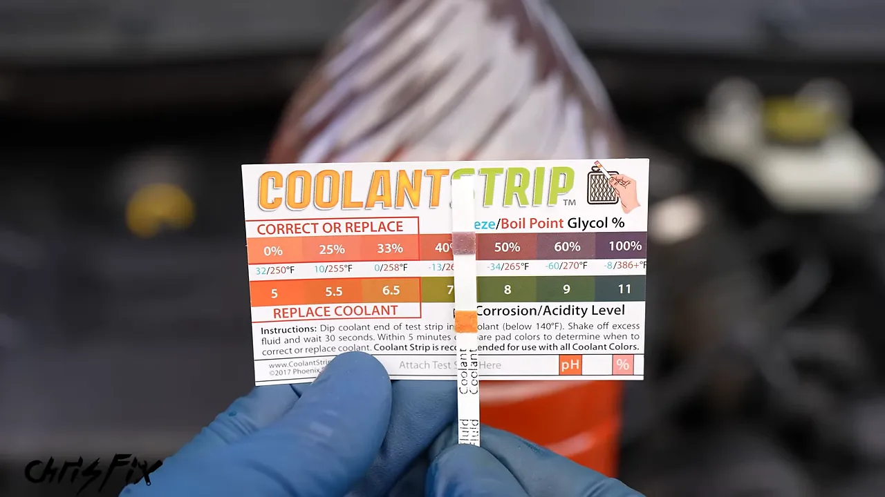 Coolant test strip held beside the concentration and pH color chart on its package