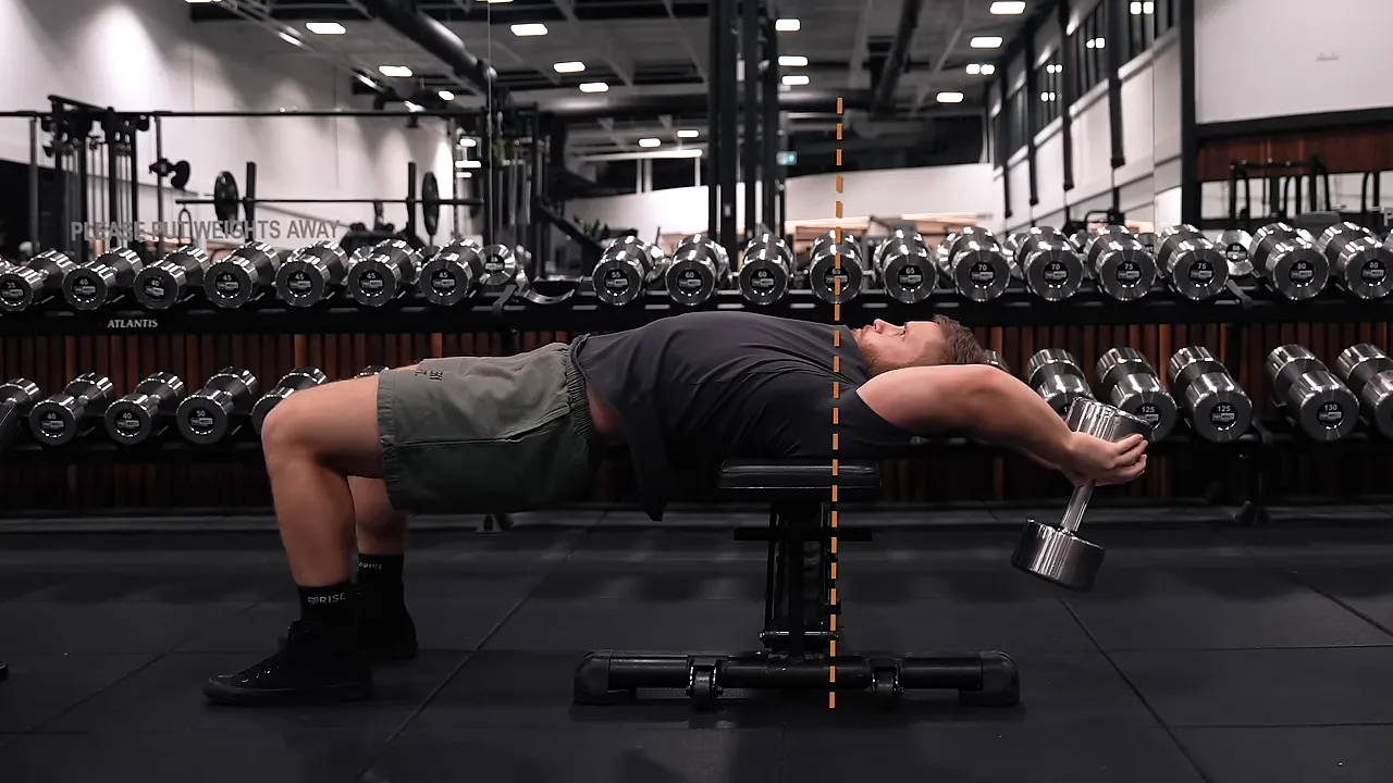 Side view of a dumbbell pullover with the dumbbell behind the head and upper back supported across a bench