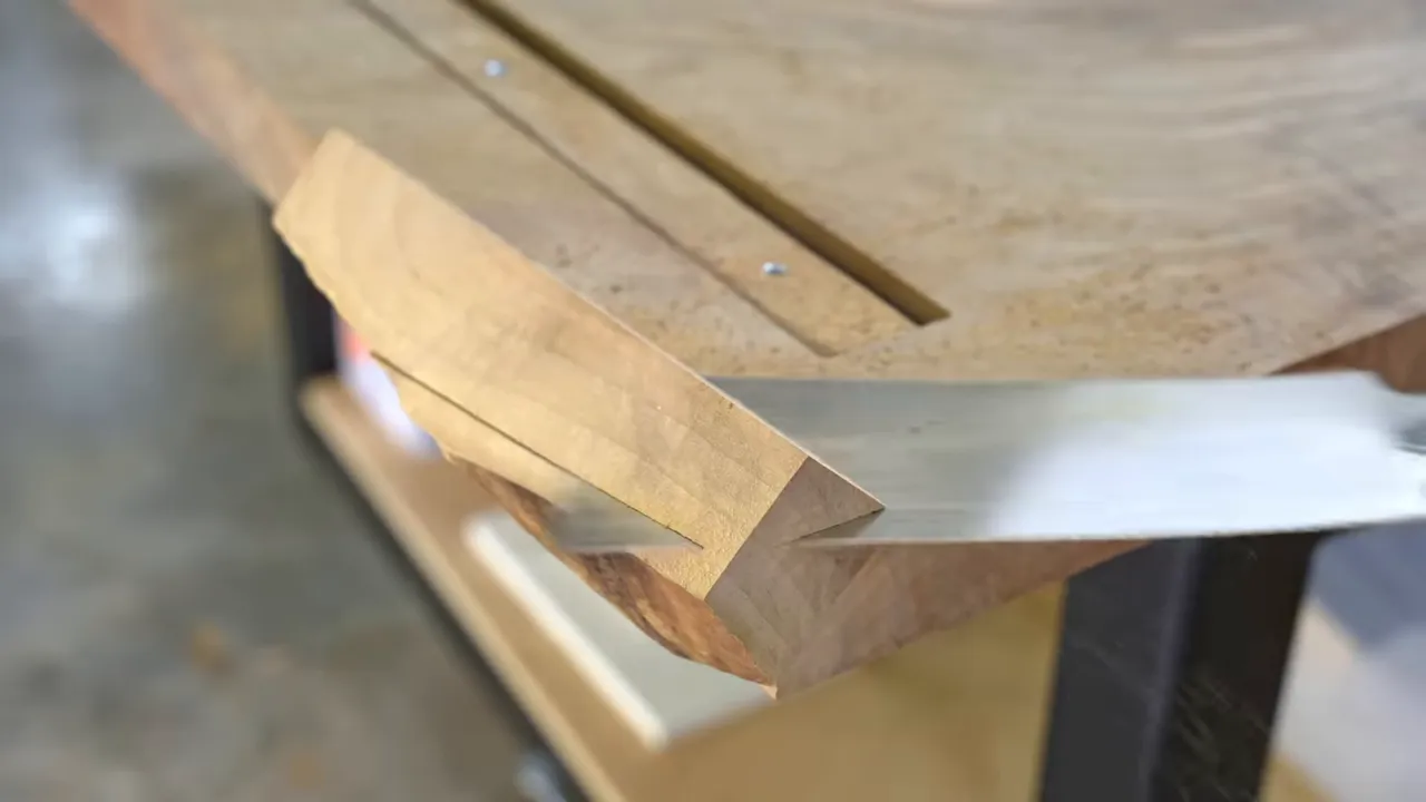 A pale wood patch at the corner of a walnut slab with a visible change in grain direction
