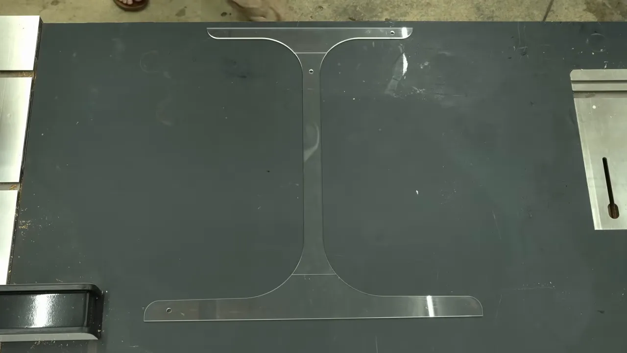 Clear acrylic templates arranged into a wineglass-shaped table leg outline on a dark work surface