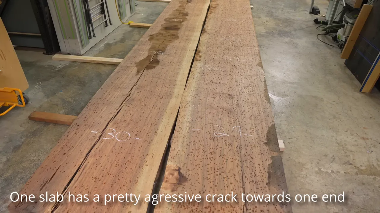 Two long walnut slabs laid side by side with natural cracks running along their surfaces