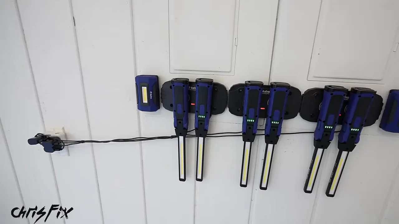 Multiple stick lights hanging from charging pads mounted on a white metal panel