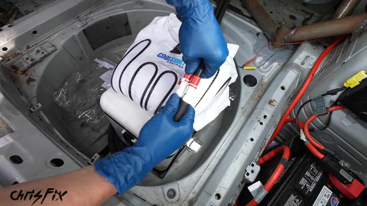 White cooling shirt with black tubing connected to hoses above the trunk-mounted cooler