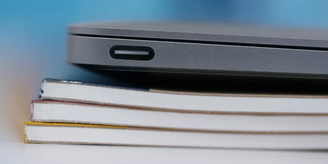 Close-up of the original 12-inch MacBook USB-C port with the laptop resting on books