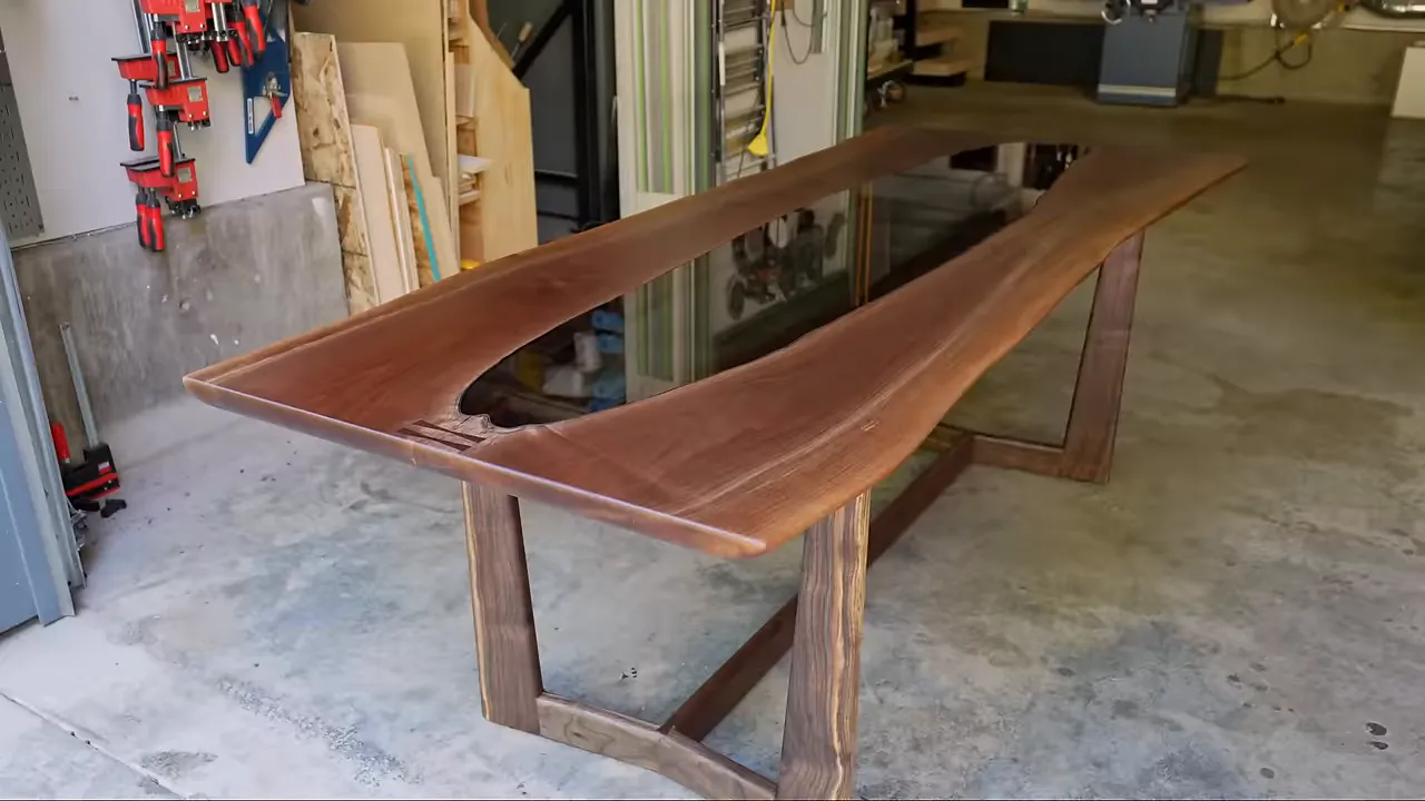 Finished walnut table with a dark glass center panel and wooden base