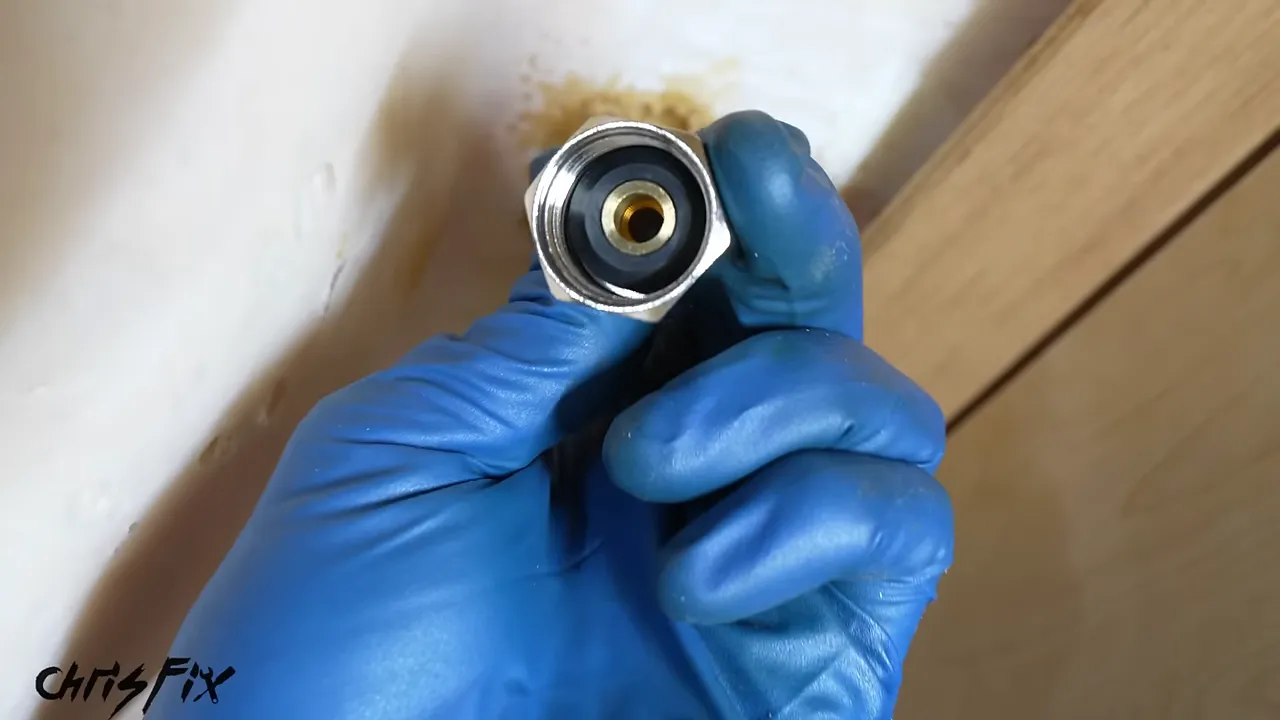 Close-up of a supply hose fitting with a black rubber gasket inside the nut