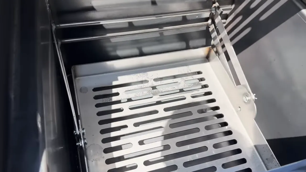 Open grill showing stainless steel fire grates positioned at different heights