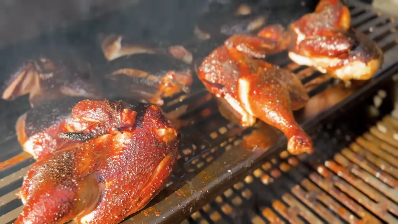 Chicken halves with glossy dark red-brown skin resting on the grill grates