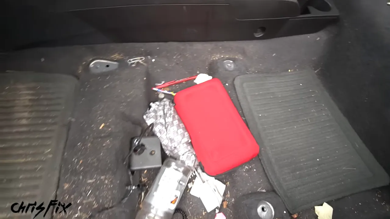 Debris scattered on the exposed carpet beside the center console after seat removal