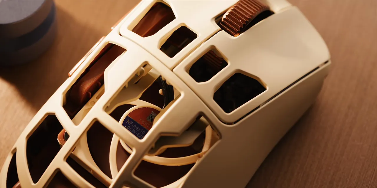 Close-up of the cream and brown mouse shell with a small fan visible inside