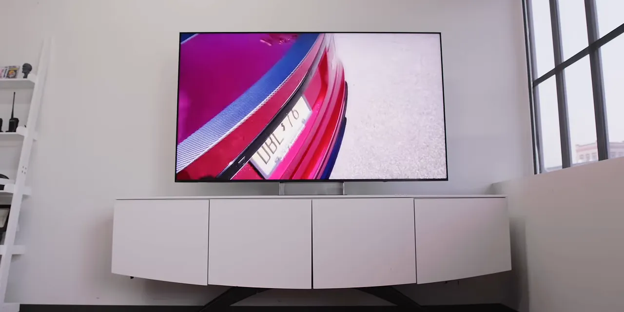 Sony television displaying a pink phone image beside large studio windows