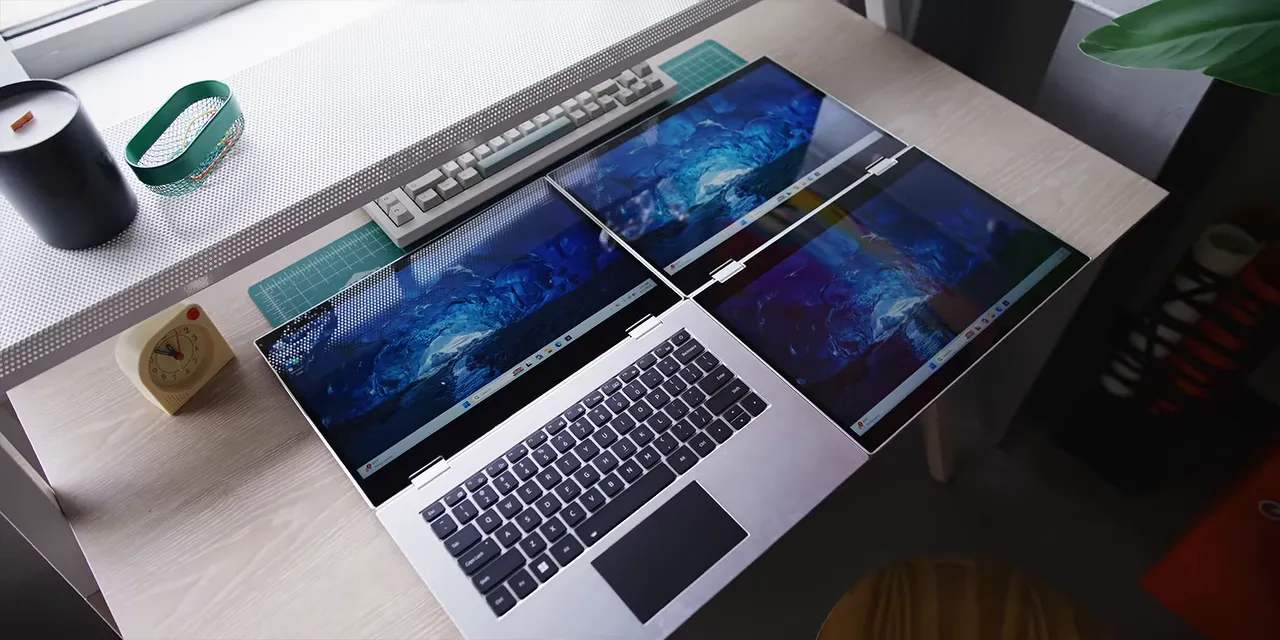 Xbook unfolded on a desk with three active displays and a keyboard