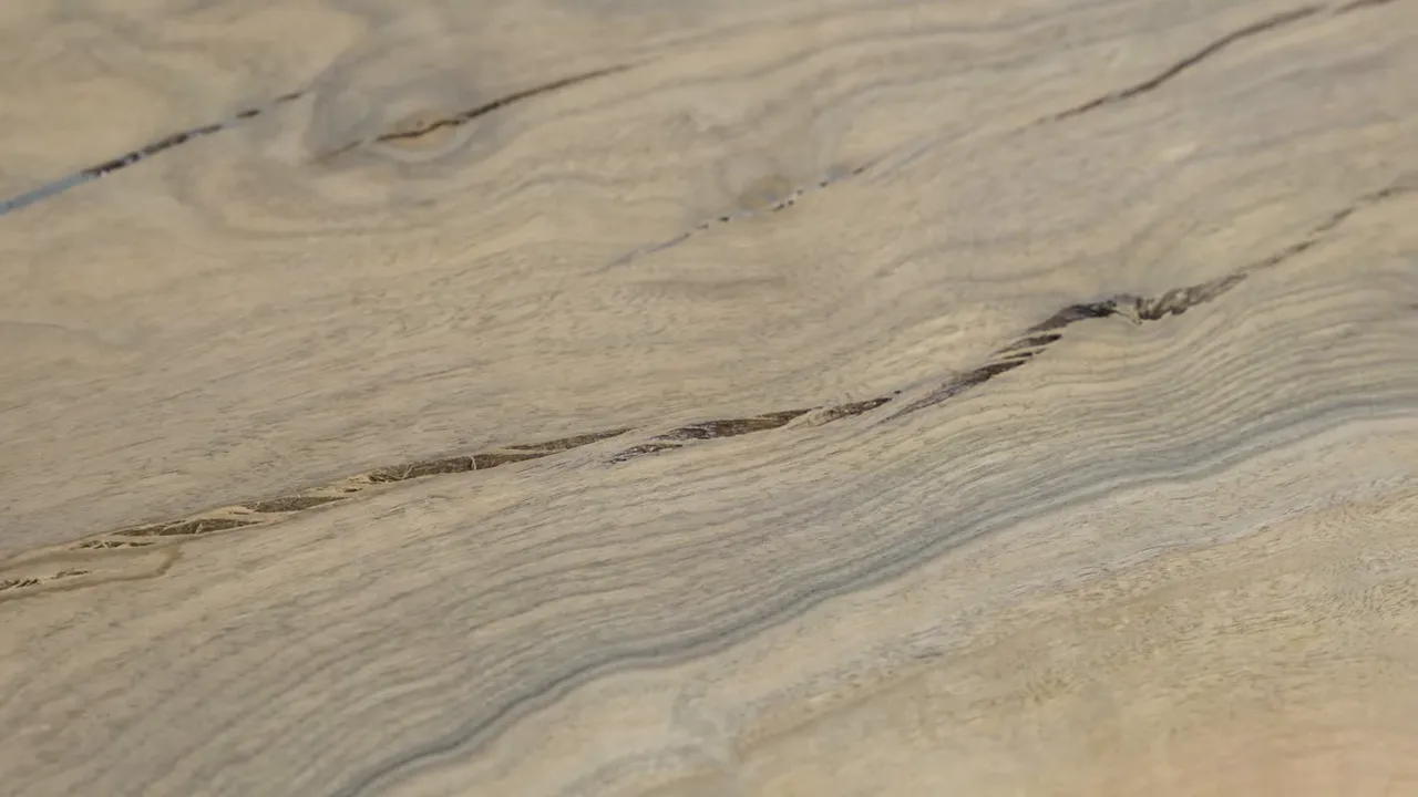 Close-up of cracks and open voids in a surfaced wood slab