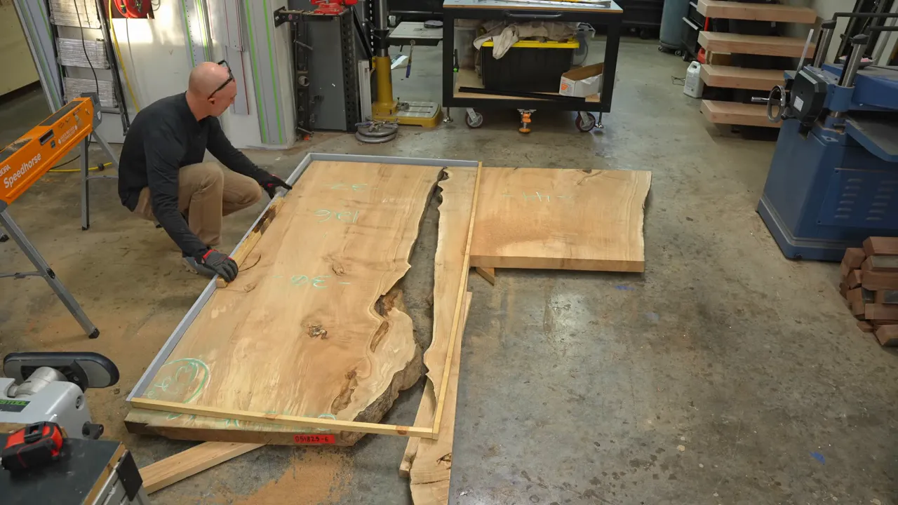Maple slab sections arranged on a workshop floor with a long narrow piece along one side