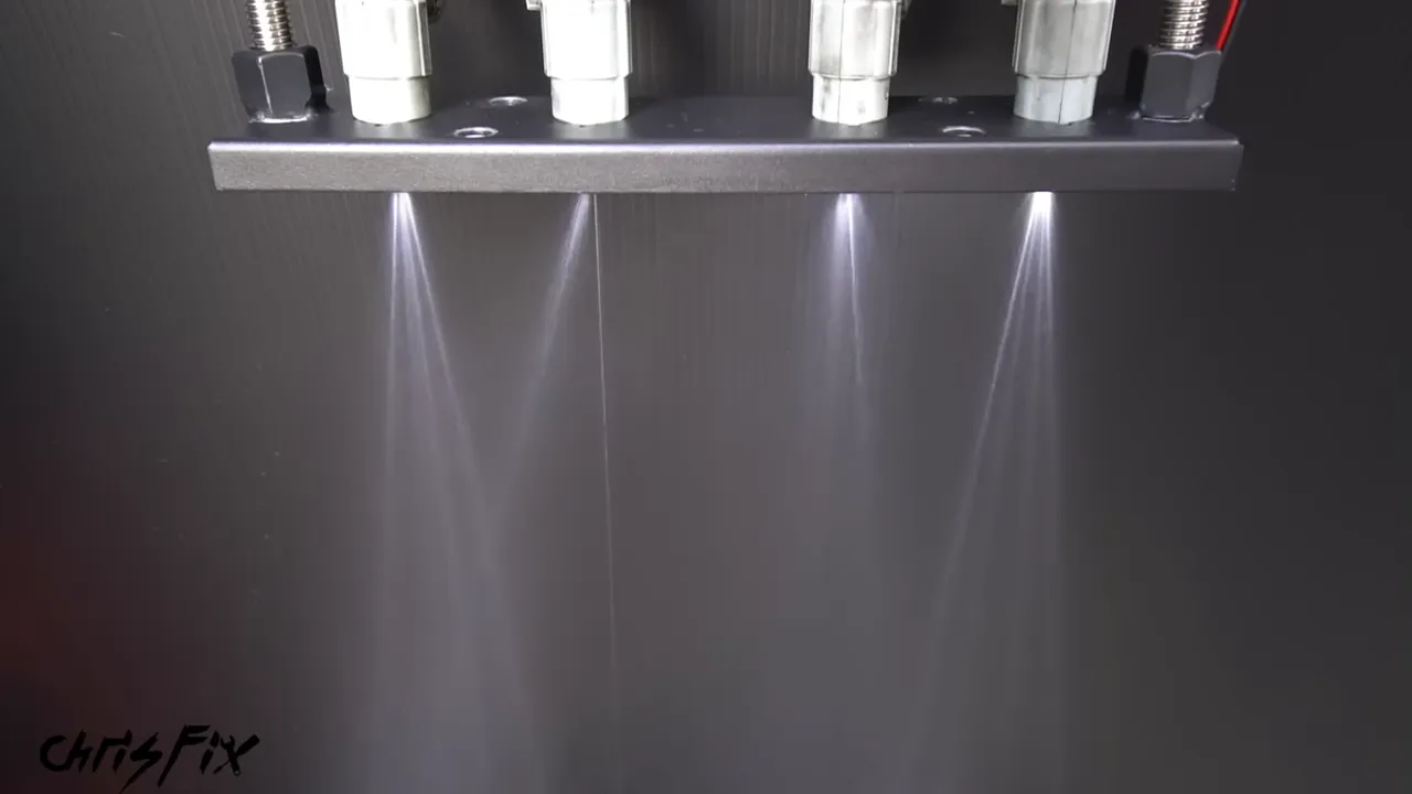 Four fuel injectors spraying with visibly different spray patterns