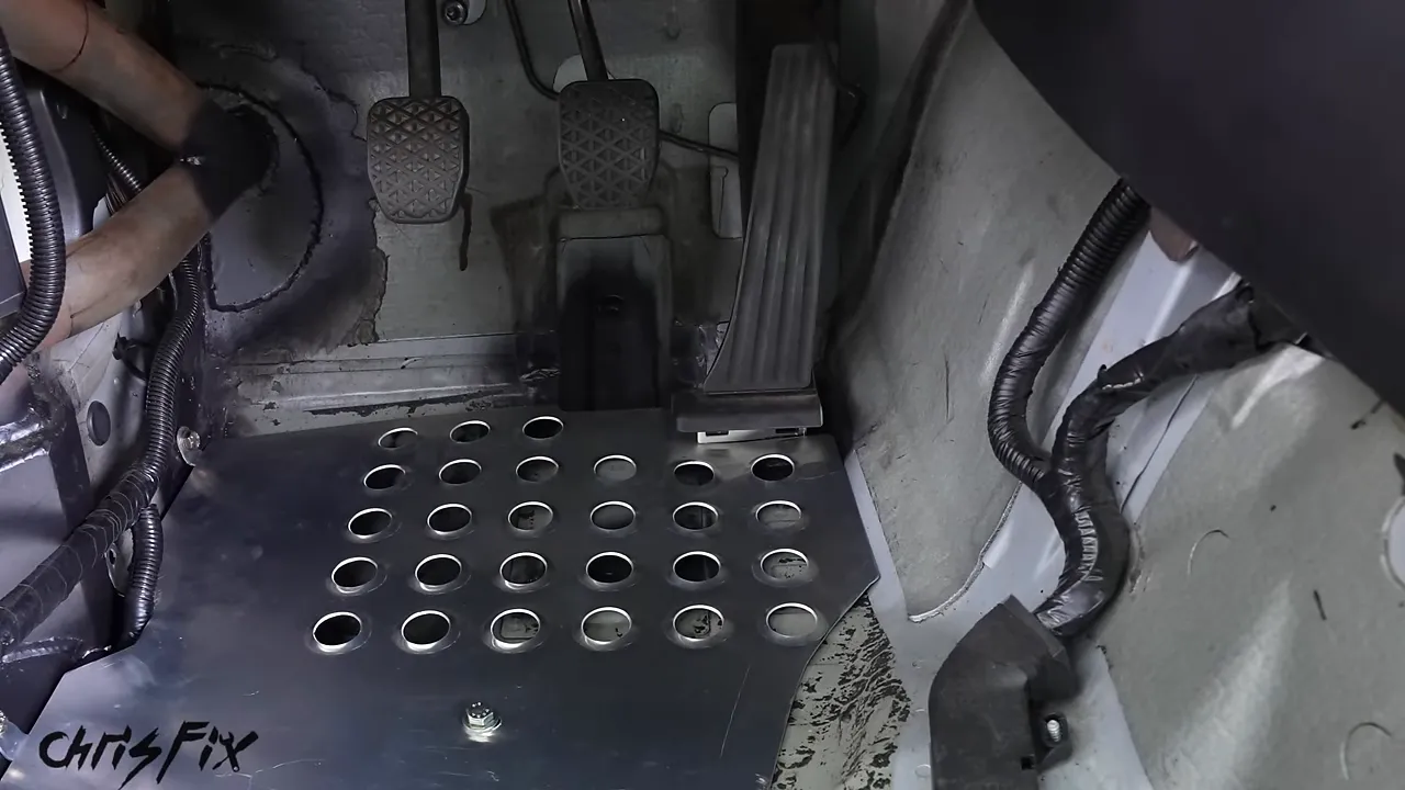 Metal heel plate installed beneath the clutch, brake, and accelerator pedals