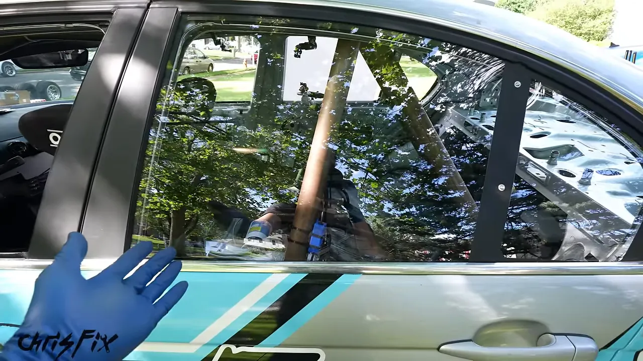 Clear rear polycarbonate window installed in the turquoise and silver BMW rear door