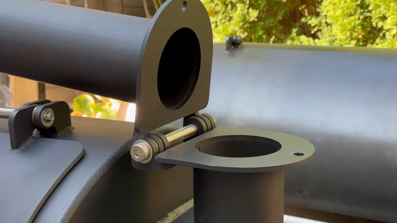 Close-up of the smoker stack folded sideways on its hinged flange
