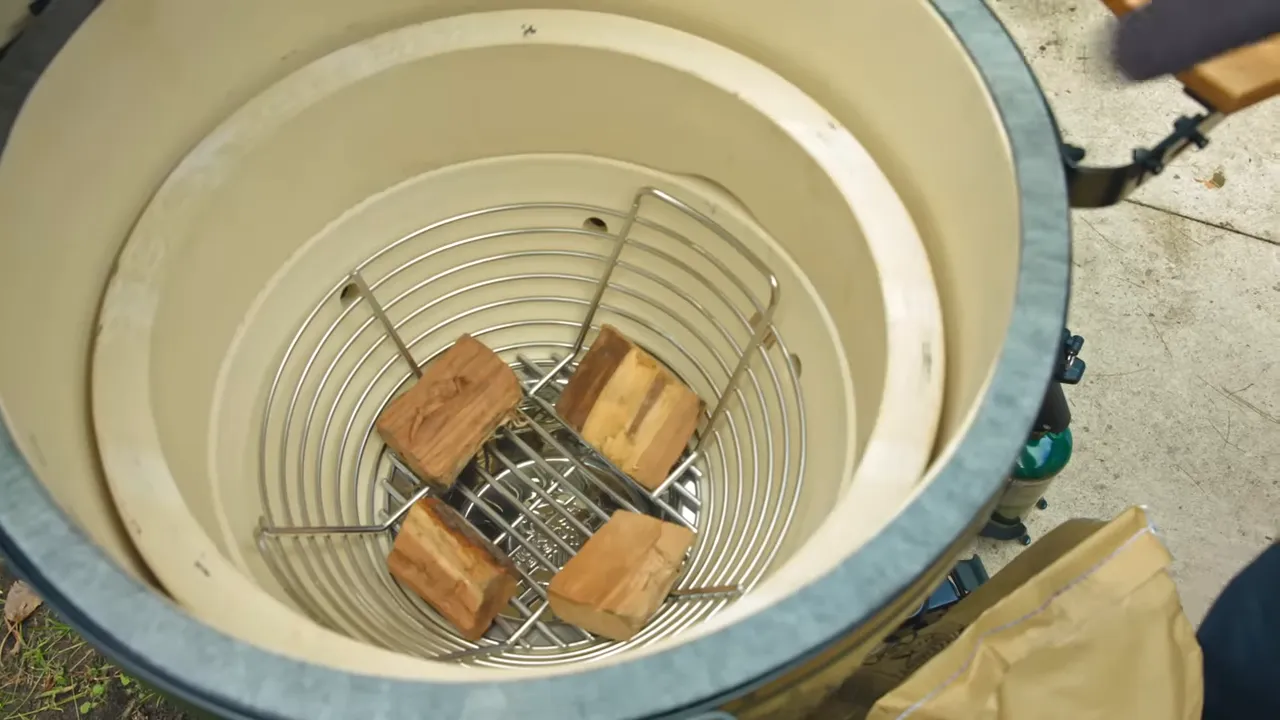 Wood chunks spaced around the bottom of an empty charcoal basket inside the Egg