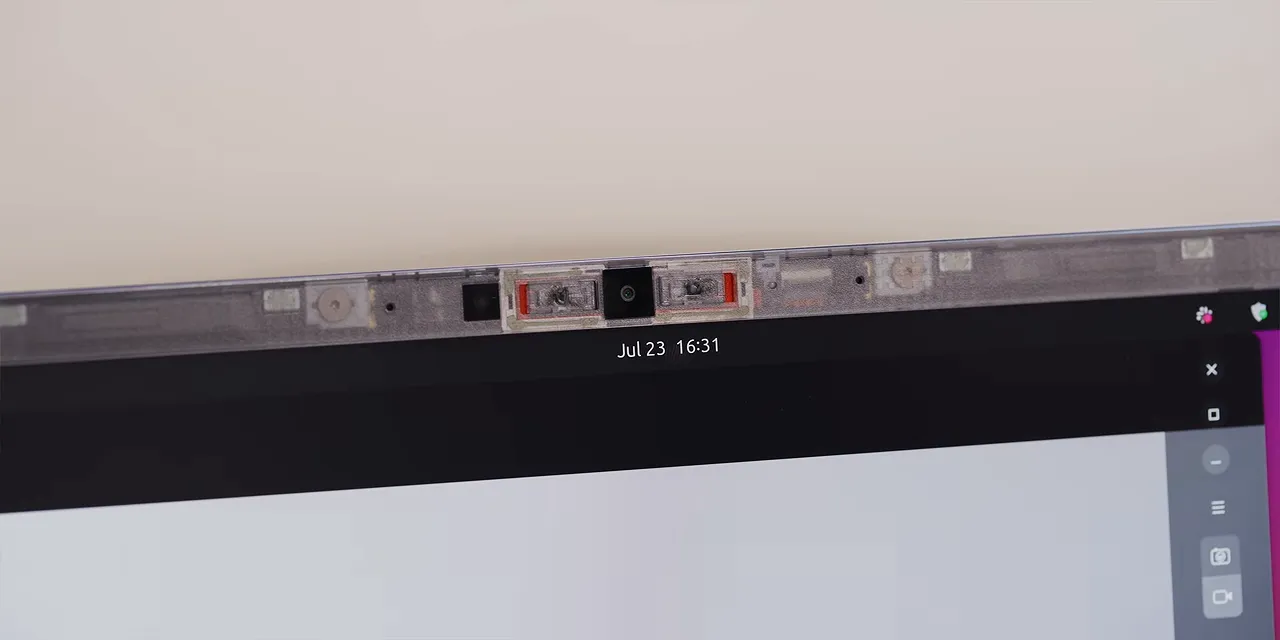 Close-up of the transparent top bezel showing the webcam and adjacent hardware switches