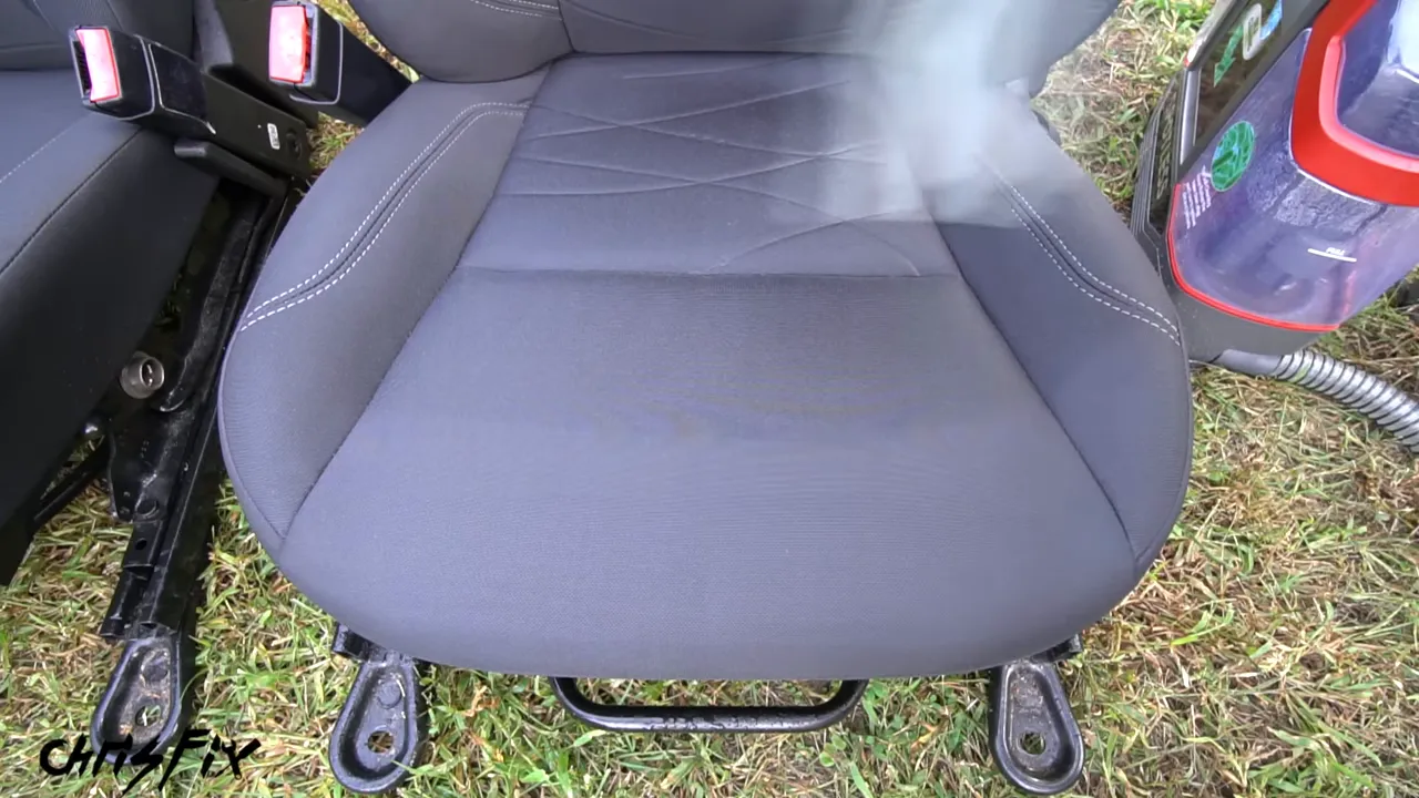 Extractor nozzle being pulled across a gray cloth seat cushion
