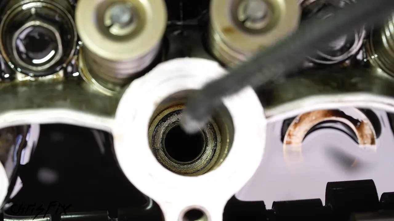Close-up of rope entering a spark plug opening in the cylinder head