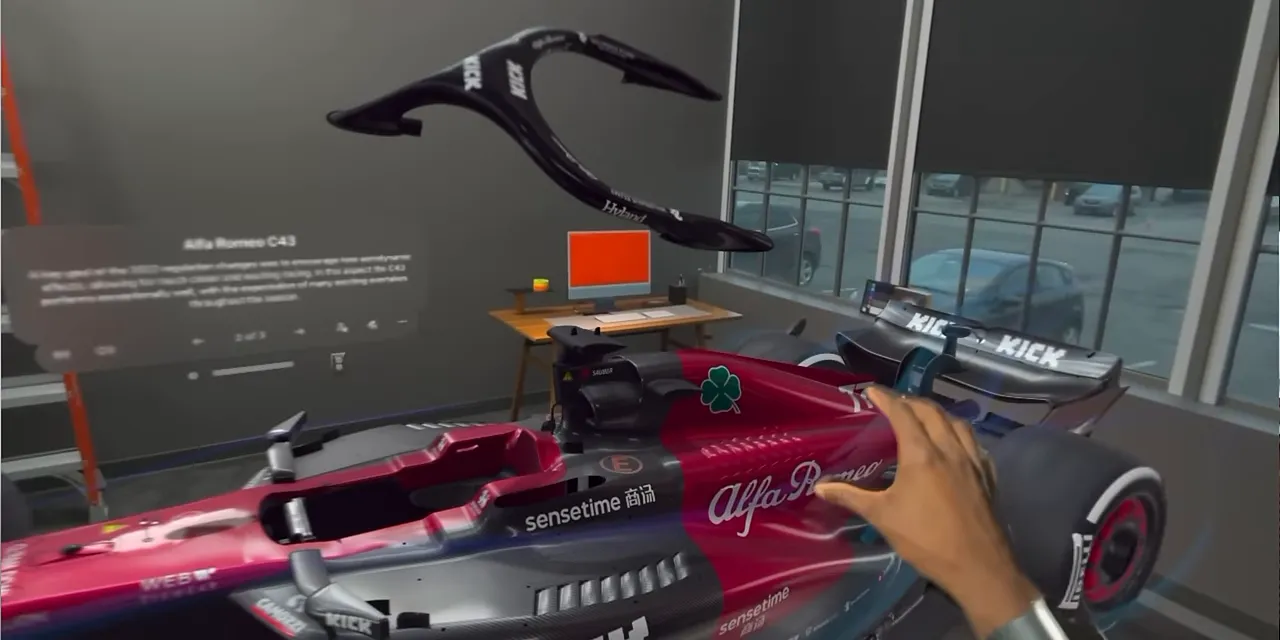 A red race car model with separated components floating inside a room in JigSpace