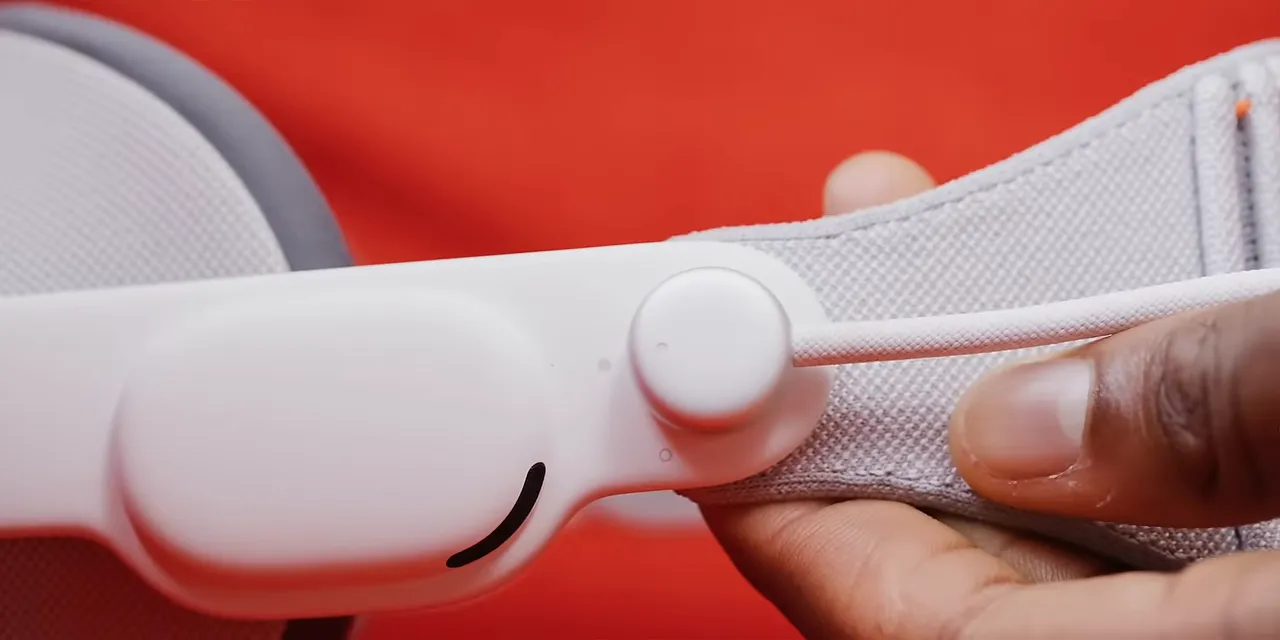 Hand turning the battery cable connector in the side of Vision Pro