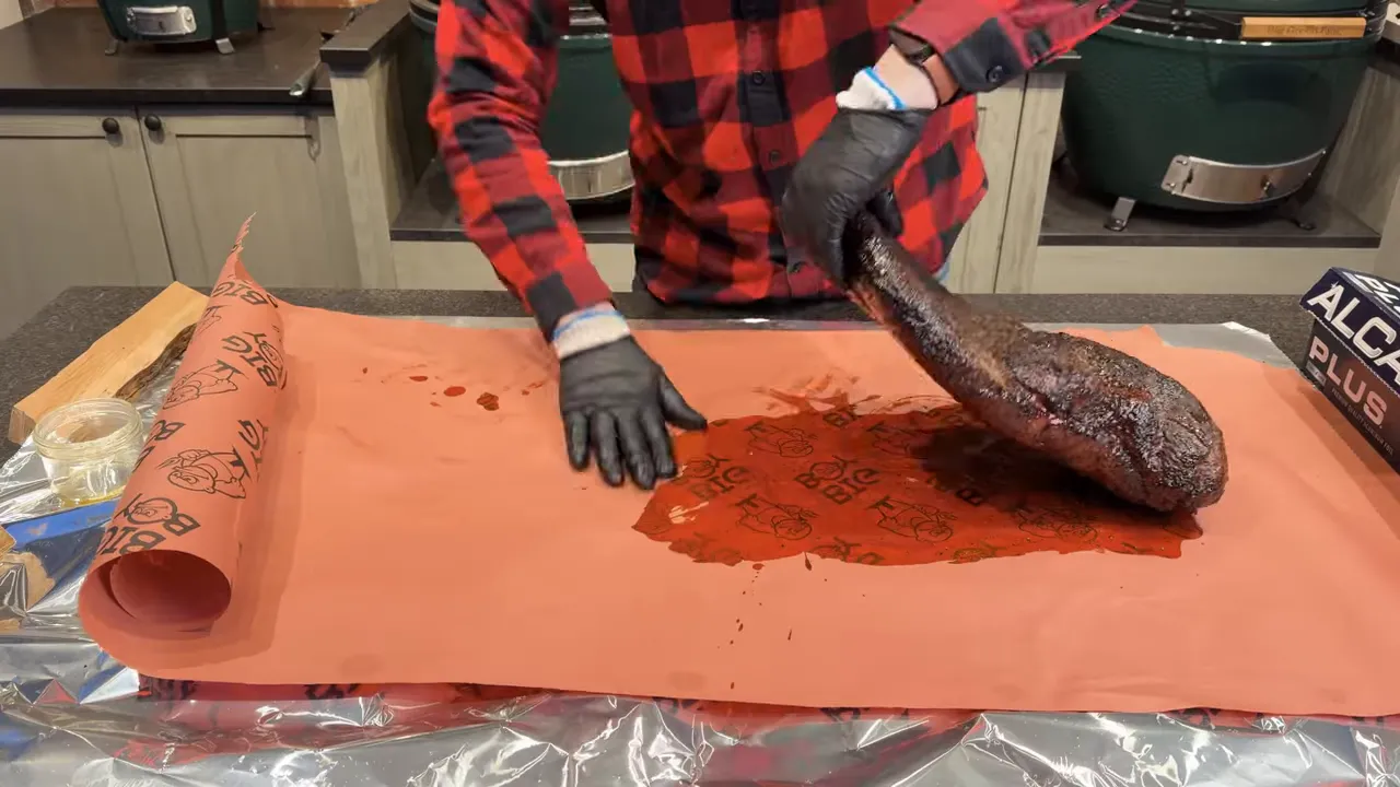 Brisket on butcher paper coated with rendered fat as the paper is folded around it