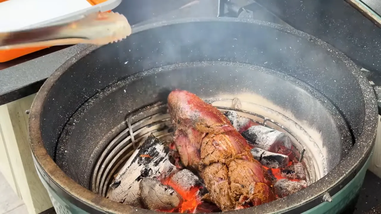 Braided tenderloin searing directly on glowing charcoal inside a Big Green Egg